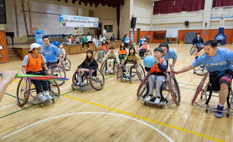 코웨이 블루휠스 휠체어농구단 선수들이 지난 7일 경기도 남양주 평내초등학교에서 학생들을 지도하고 있다. 코웨이 제공