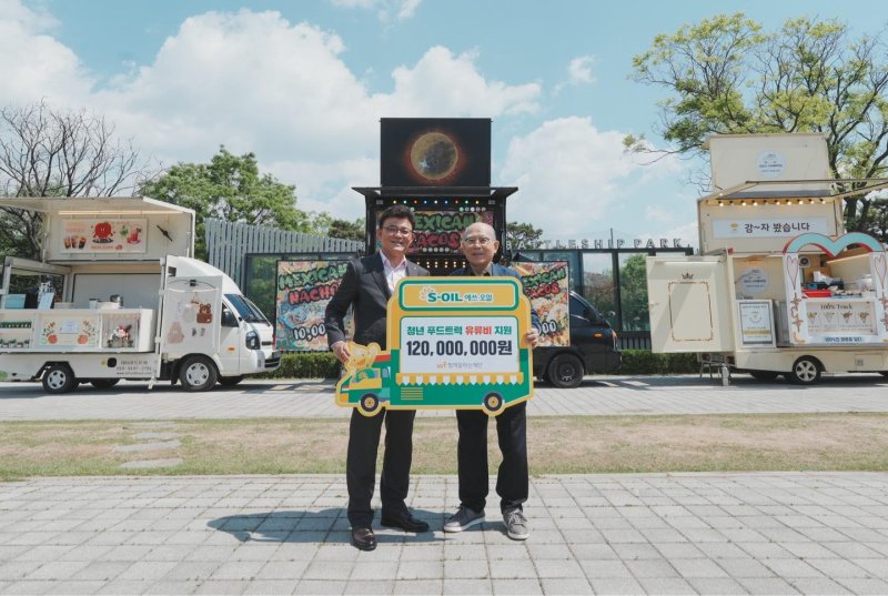 안종범 에쓰오일 마케팅총괄 사장(왼쪽)이 8일 서울 마포구 망원한강공원에서 열린 '청년 푸드트럭 유류비 전달식'에서 이세중 함께일하는재단 이사장과 기념촬영을 하고 있다. 에쓰오일 제공