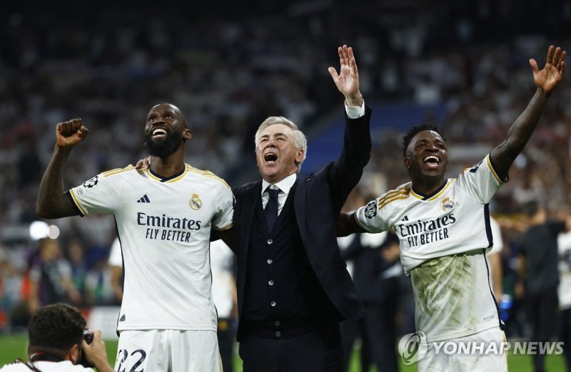 뤼디거와 안첼로티 감독,비니시우스(왼쪽부터) Soccer Football - Champions League - Semi Final - Second Leg - Real Madrid v Bayern Munich - Santiago Bernabeu, Madrid, Spain - May 8, 2024 Real Madrid's Antonio Rudiger, coach Carlo Ancelotti and Vinicius Junior celebrate after the match REUTERS/Susana Vera