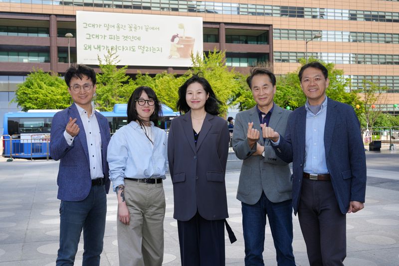 교보생명이 광화문글판 문안선정위원회에 이슬아 수필가 후임으로 가수이자 작가인 요조(본명 신수진)씨가 합류해 이번 여름편 문안선정위원회부터 활동한다고 9일 밝혔다. 사진 왼쪽부터 장재선 문화일보 부국장, 가수 겸 작가 요조(본명 신수진), 김행숙 시인(강남대학교 교수), 이승우 소설가(조선대 교수), 곽효환 시인(한국문학번역원장). 교보생명 제공