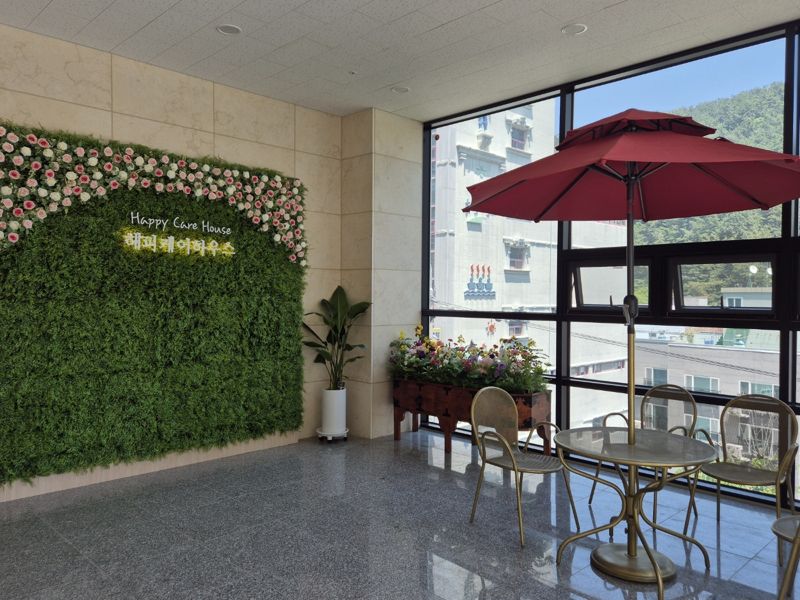 빌딩 3층 복도에 꽃으로 장식된 해피케어하우스 포토존. BS그룹 제공