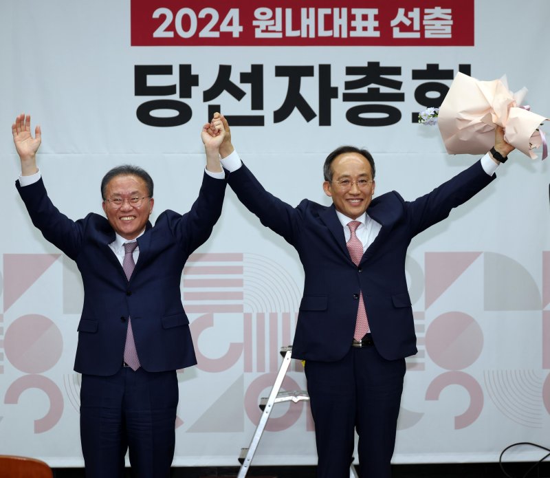 추경호 국민의힘 신임 원내대표가 9일 오후 서울 여의도 국회에서 열린 제22대 원내대표 선출 당선자총회에서 윤재옥 전 원내대표와 함께 손을 들어보이고 있다.뉴스1화상