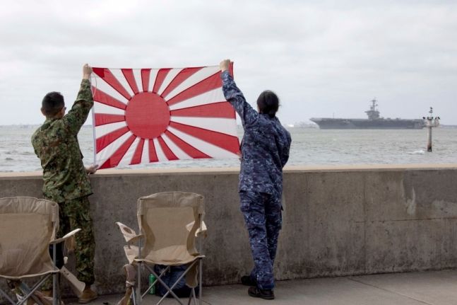 일본 전범기를 들고 있는 군인들의 모습이 담긴 사진. 사진=미국 해군 SNS 캡처