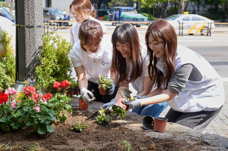 BAT로스만스 임직원들이 지난 9일 서울 중구 골목길에 꽃을 심고 있다.