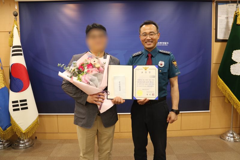 변민선 성동경찰서장(오른쪽)과 보이스피싱 피의자 검거에 기여한 시민이 표창 수여식에서 기념촬영하고 있다. 사진=성동경찰서