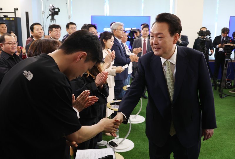 윤석열 대통령이 14일 서울 중구 서울고용복지플러스센터에서 열린 스물다섯번째 '국민과 함께하는 민생토론회'에 입장하며 참석자들과 악수하고 있다. 이날 토론회는 '고맙습니다, 함께 보듬는 노동현장'을 주제로 진행됐다. 사진=연합뉴스