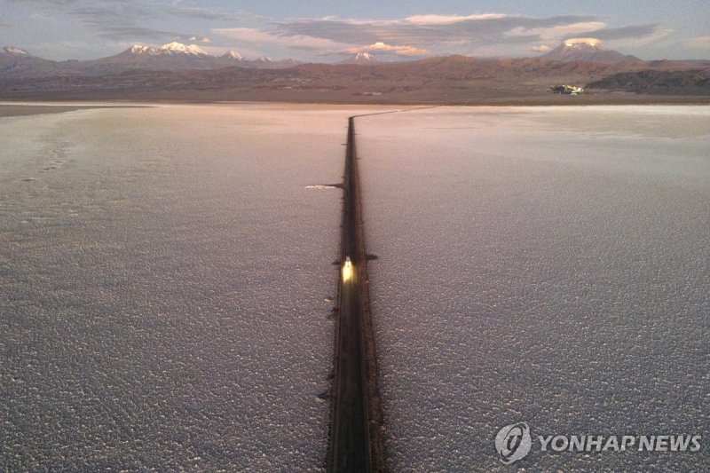 칠레 아타카마 염호 전경 A car drives down a road through the Salar de Atacama salt flat near the Albemarle lithium mine in Chile, Monday, April 17, 2023. (AP Photo/Rodrigo Abd)