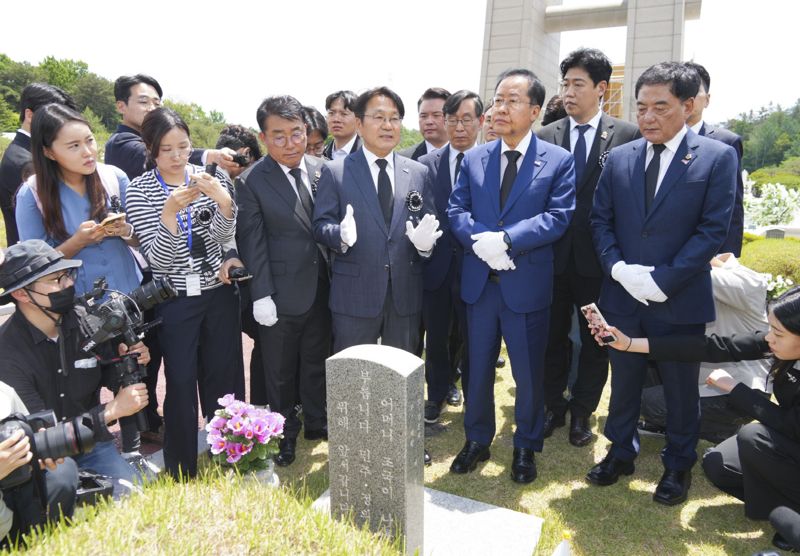 강기정 광주광역시장과 홍준표 대구광역시장이 17일 윤상원 열사와 전영진 열사 묘소를 찾아 추모하고 있다. 강 시장은 홍 시장에게 민주주의를 위해 산화한 윤상원 열사와 전영진 열사를 직접 소개하며 영령들의 뜻을 되새겼다. 광주광역시 제공