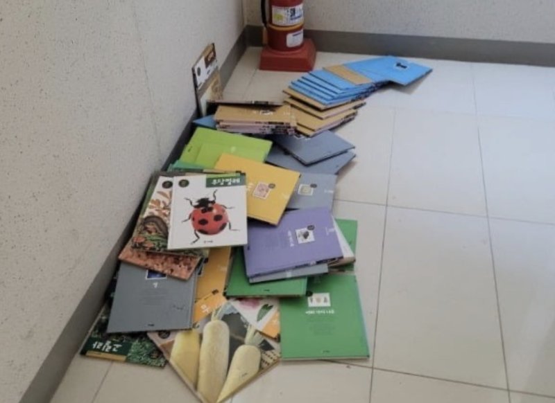 [서울=뉴시스] 중고 거래 플랫폼 ‘당근'(옛 당근마켓)에서 유아용 책을 무료나눔 받으려다 책들을 쓰레기 버리듯 복도에 내팽개쳐 놓은 것을 보고 황당했다는 이용자의 사연이 지난 14일 온라인 커뮤니티에 공유됐다. 사진은 해당 책이 내팽겨쳐져 있는 모습. (사진=온라인 커뮤니티 갈무리) 2024.5.17 *재판매 및 DB 금지