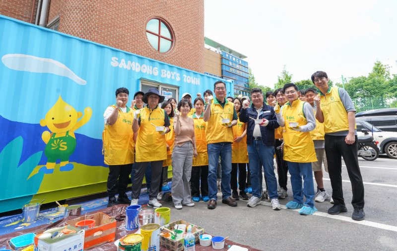 정영광 에쓰오일 부문장(맨 앞줄 가운데)이 지난 18일 서울 마포구 삼동보이스타운에서 열린 벽화그리기 자원봉사 활동에서 참석자들과 기념촬영을 하고 있다. 에쓰오일 제공