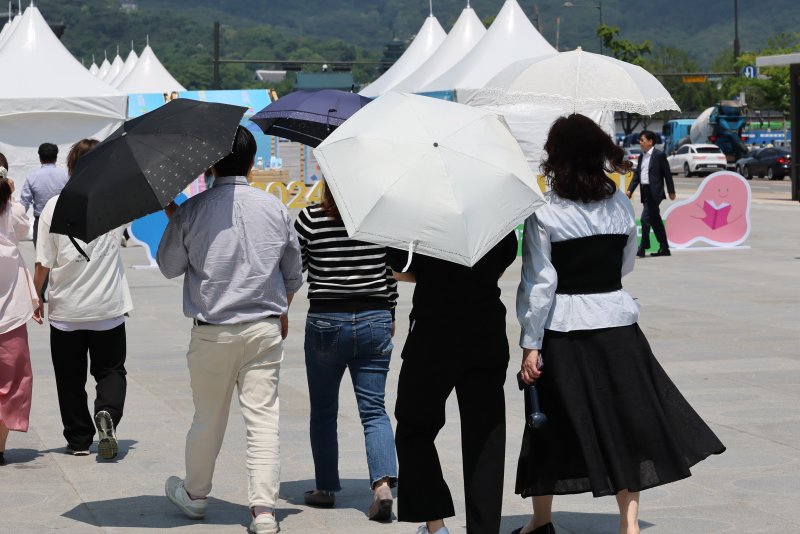 초여름 날씨를 보인 지난 21일 서울 광화문광장에서 양산을 쓴 시민들이 걷고 있다. 연합뉴