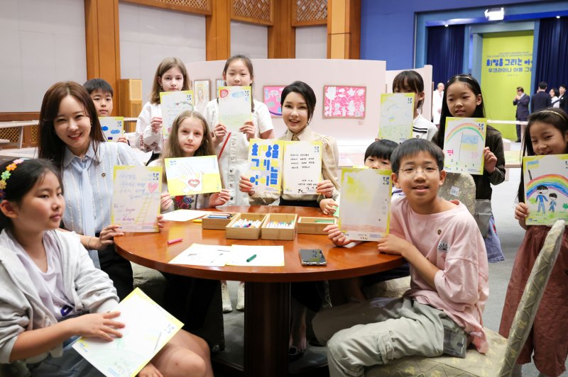 윤석열 대통령 부인 김건희 여사가 21일 청와대 춘추관에서 열린 '희망을 그리는 아이들: 우크라이나 아동 그림전'을 찾아 아이들과 함께 희망의 메시지를 들고 기념촬영을 하고 있다. (대통령실 제공) /사진=뉴스1