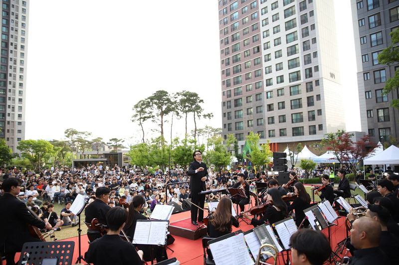 지난 25일 충남 아산시 '한들물빛도시 지웰시티 센트럴 푸르지오'에서 입주민들이 오케스트라 연주를 듣고 있다. 대우건설 제공