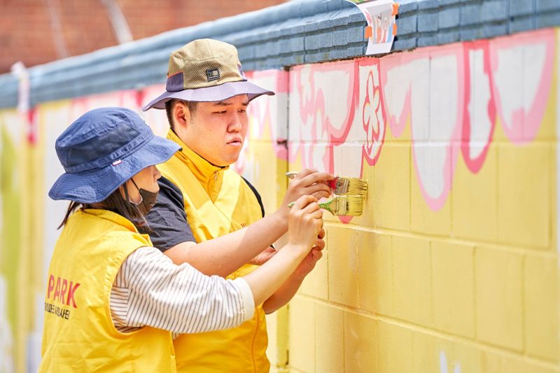 지난 24일 서울 용산구 삼광초등학교에서 HDC그룹 임직원들이 벽화그리기 봉사활동을 진행하고 있다. HDC현대산업개발 제공