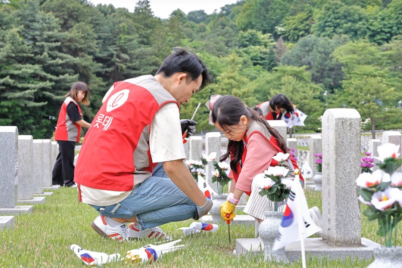 지난 25일 서울 동작구 동작동 국립서울현충원에서 롯데건설의 임직원과 가족들이 봉사활동을 하고 있다. 롯데건설 제공