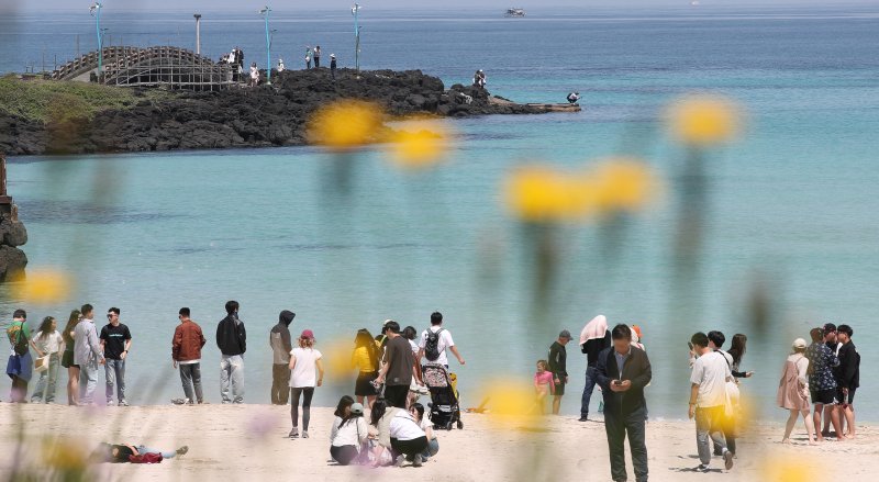 완연한 초여름 날씨를 보인 10일 제주시 조천읍 함덕해수욕장을 찾은 관광객들이 시원한 바닷바람을 쐬며 즐거운 시간을 보내고 있다. <뉴시스>