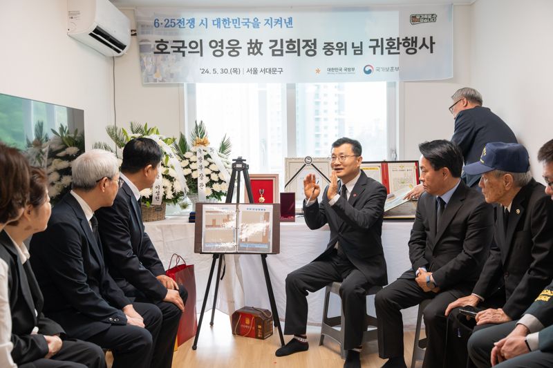 이근원 국방부 유해발굴감식단장이(사진 가운데) 30일 서울시 서대문구에 있는 유가족 자택에서 진행된 고 김희정 중위의 '호국의 영웅 귀환 행사'에서 유가족에게 고인의 참전 과정과 유해발굴 경과를 설명하고 있다. 사진=국유단 제공