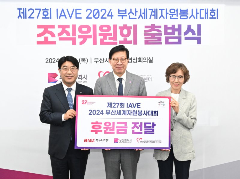 BNK부산은행 방성빈 은행장(왼쪽)이 제27회 IAVE부산세계자원봉사대회 조직위 출범식에 참석해 후원금을 전달하고 박형준 부산시장(가운데), 한국중앙자원봉사센터 박윤애 이사장과 기념촬영을 하고 있다. BNK부산은행 제공