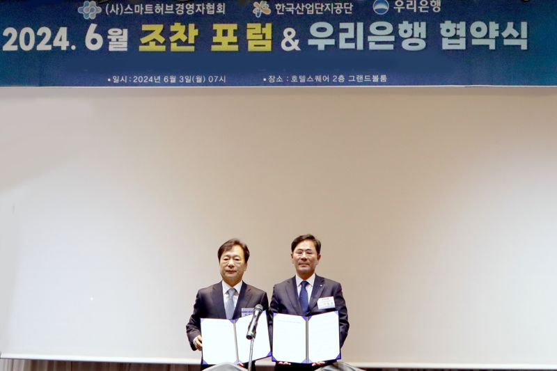 우리은행이 3일 경기도 안산시 호텔스퀘어에서 스마트허브경영자협회와 업무협약을 맺었다. 기동호 우리은행 기업투자금융부문장(오른쪽)과 최철호 스마트허브경영자협회장이 기념사진을 찍고 있다. 우리은행 제공