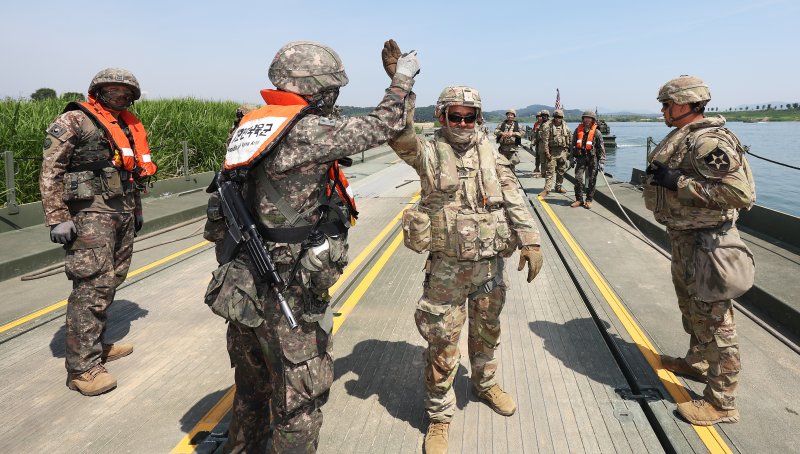 5일 경기도 여주시 남한강 일대에서 열린 한미 연합 도하 훈련에서 육군 7공병여단과 미2사단/한미연합사단 장병들이 부교를 설치하며 하이파이브를 하고 있다. 이번 훈련에는 육군 7공병여단과 2항공여단 301항공대대, 2기갑여단 기계화보병대대, 미2사단/한미연합사단 다목적 교량중대 등에서 총 590여명의 장병이 참가했다. 사진=연합뉴스