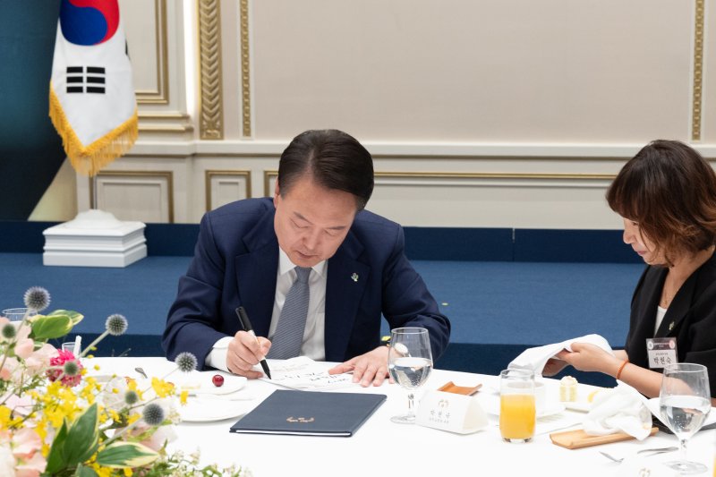 [서울=뉴시스] 최진석 기자 = 윤석열 대통령이 6일 서울 청와대 영빈관에서 열린 국가유공자 및 보훈가족 초청 오찬에서 참석자의 이름이 적힌 냅킨에 사인을 해주고 있다. (사진=대통령실 제골) 2024.06.06. photo@newsis.com *재판매 및 DB 금지