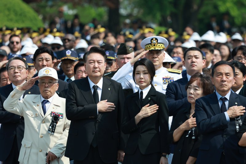 윤석열 대통령과 부인 김건희 여사가 6일 서울 동작구 국립서울현충원에서 열린 제69회 현충일 추념식에서 국기에 경례하고 있다. 윤 대통령은 이날 추념사를 통해 최근 오물풍선을 살포한 북한을 겨냥, 비판하면서 압도적인 대응을 다짐한 데 이어 "국가와 국민을 위해 자신의 모든 것을 희생한 영웅들에게 최고의 예우로 보답할 것"이라며 국가유공자 의료서비스 개선 등 보훈정책 강화 의지를 피력했다. 연합뉴스