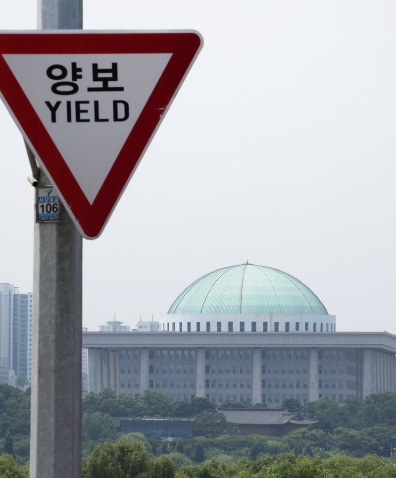 국회는 어디로 여야가 22대 국회 상임위원회를 배분하는 원구성 문제를 두고 강대강 대치를 이어가고 있는 9일 서울 마포구 서강대교에 설치된 교통표지판 너머로 국회의사당이 보인다. 연합뉴스