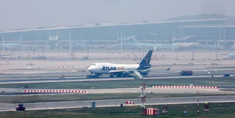 11일 인천공항 활주로에서 정비 관계자들이 타이어 파열로 멈춰 선 아틀라스 항공 화물기를 살펴보고 있다. 사진=박범준 기자