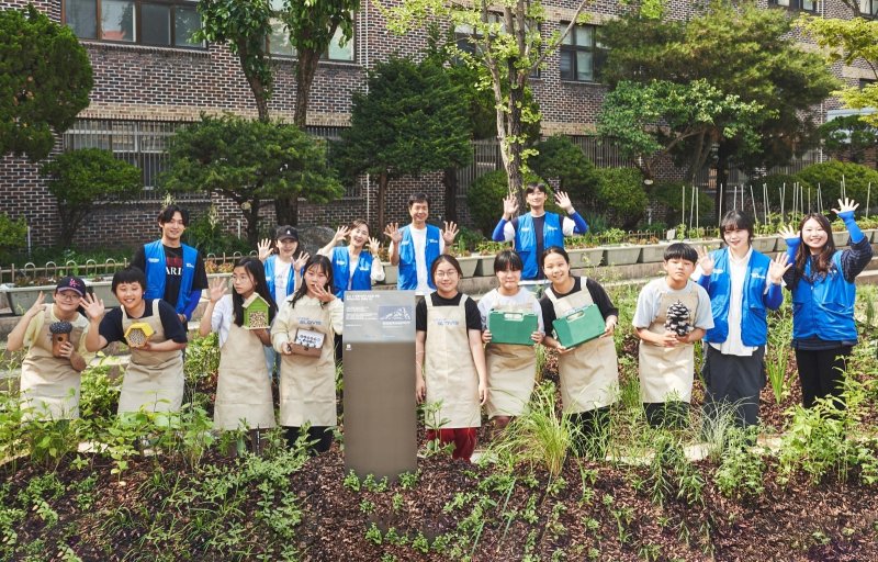 현대글로비스 임직원들이 이달 환경의 달을 맞아 서울 상원초등학교 학생들과 도심 생태숲을 조성하고 기념촬영을 하고 있다. 현대글로비스 제공