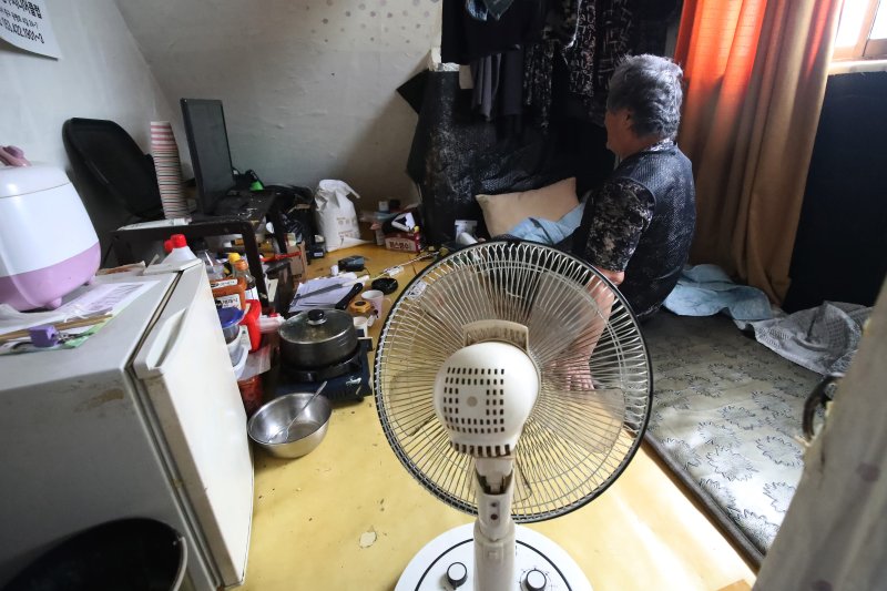 불볕더위가 기승을 부리며 전국 대부분 지역에 폭염특보가 발효된 19일 대구의 한 쪽방촌에서 주민이 선풍기 하나에 의지해 앉아 있다. 2024.6.19/뉴스1 ⓒ News1 공정식 기자
