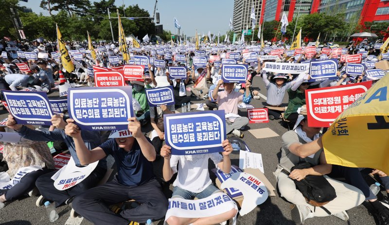 [서울=뉴시스] 김진아 기자 = 대한의사협회가 의대 증원과 관련해 집단 휴진에 돌입한 지난 18일 서울 영등포구 여의도 환승센터 주변에서 열린 대한의사협회 전국 의사 총궐기대회에서 참석자들이 손팻말을 들고 있다. 2024.06.18. bluesoda@newsis.com