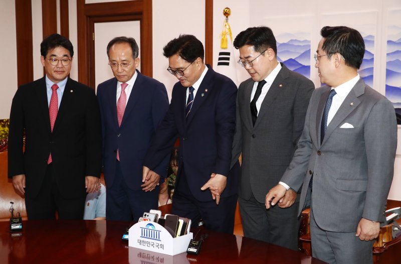 우원식 국회의장과 여야 원내대표가 21일 오후 서울 여의도 국회 의장실에서 가진 원 구성 관련 회동에서 손을 맞잡고 있다. 왼쪽부터 국민의힘 배준영 원내수석부대표, 추경호 원내대표, 우 의장, 더불어민주당 박찬대 원내대표, 박성준 원내수석부대표. 뉴스1