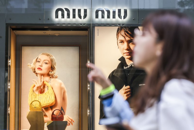 [서울=뉴시스] 정병혁 기자 = 7일 서울시내 백화점 미우미우 광고판 앞에서 시민들이 이동하고 있다. 2024.05.07. jhope@newsis.com