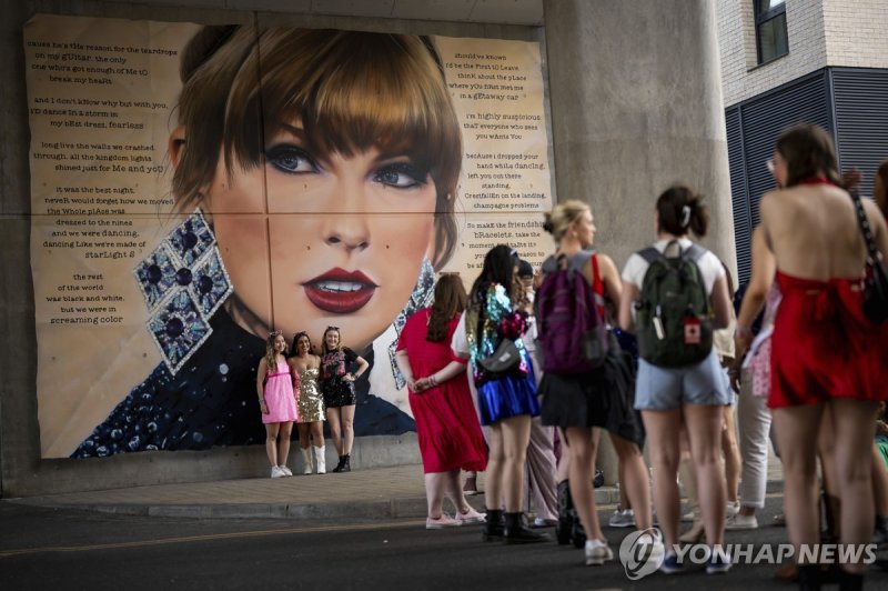 스위프트 벽화 앞에 선 팬들 Taylor Swift fans pose for a photograph besides a mural, commissioned by London Mayor Sadiq Khan, before the first London concert of the Eras Tour on Friday, June 21, 2024 in London. (Photo by Scott A Garfitt/Invision/AP) 062124130575, 21334631,