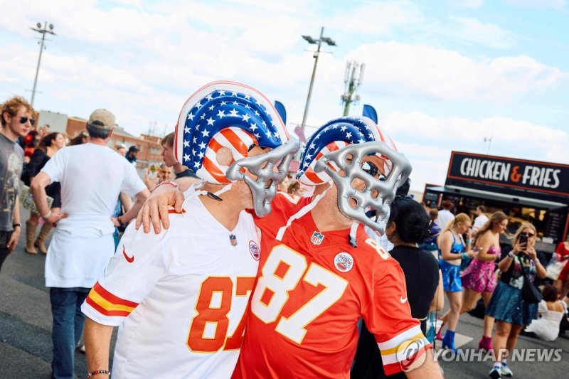 스위프트의 연인 NFL 켈시처럼 차려입은 팬들 Fans dressed as American football player Travis Kelce pose as Swifties arrive to attend the concert of US singer and songwriter Taylor Swift as part of her 'Eras Tour' at Wembley Stadium, west of London, on June 21, 2024. The tour is set to boost the UK economy by almost £1