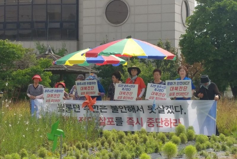 24일 월롱면 주민들 20여명이 남북중앙교회 옆 꽃밭에서 대북전단 살포를 반대하는 집회를 진행하고 있다. /파주시 제공