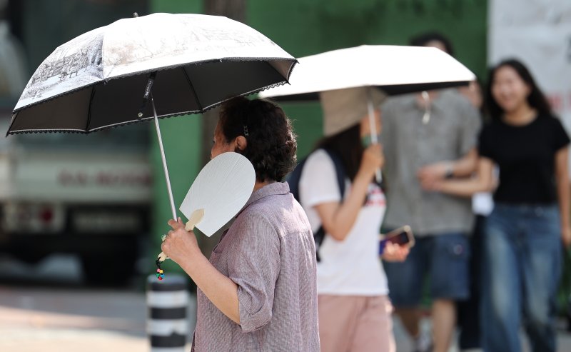 전국 곳곳에 폭염주의보가 발효된 지난 19일 대구 중구 동성로에서 한 시민이 부채를 들고 이동하고 있다. 뉴시스