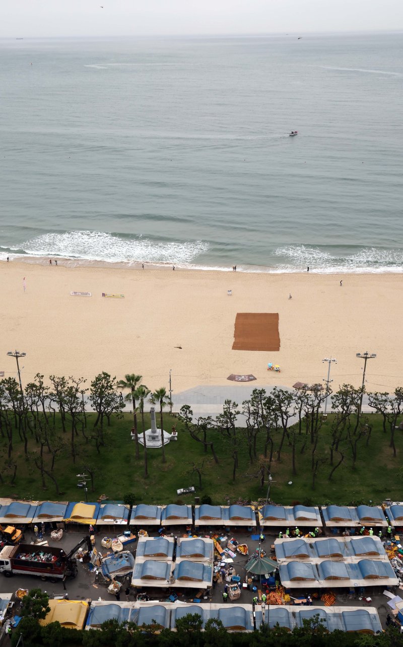 [부산=뉴시스] 하경민 기자 = 1960년대 초부터 영업을 한 부산 해운대 바다마을 포장마차촌이 추억 속으로 사라졌다. 25일 해운대구청 관계자들이 중장비를 동원해 포장마차촌을 철거하고 있다. 이 포장마차촌은 시유지 무단점용과 무신고 영업행위 등 논란이 끊이지 않았고, 해운대구는 2021년 상인들과 2년6개월의 유예기간을 거쳐 올 1월31일 자진 철거하기로 합의하고 이날 최종 철거에 나섰다. 2024.06.25. yulnetphoto@newsis.com