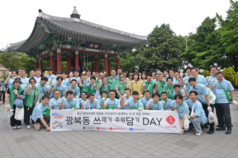 부산롯데타워TF팀이 지난 25일 광복동 주민센터, 광복동 새마을단체 등과 함께 부산 중구 광복동 일대에서 환경정화 활동을 펼친 후 기념촬영을 하고 있다. 롯데백화점 제공