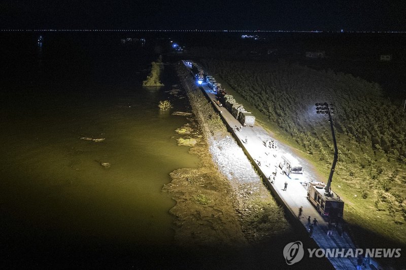 (240705) -- CHANGSHA, July 5, 2024 (Xinhua) -- An aerial drone photo taken on July 5, 2024 shows rescuers working on a dike of Dongting Lake in Tuanzhou Township, Huarong County under Yueyang City, central China's Hunan Province. A dike breach in Dongting Lake in central China's Hunan Province occur