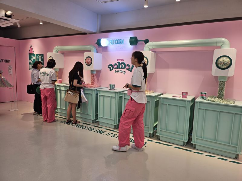 지난 5일 서울 성동구 성수 달달팩토리에서 고객들이 '디지트 생산라인 직원'으로 팝콘 정량을 맞추는 체험을 하고 있다. 오픈 첫 날 달달팩토리에는 900명의 인원이 몰렸다. 사진=김나경 기자