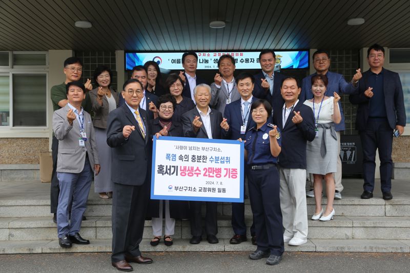 부산구치소 교정협의회 관계자들이 수용자들을 위한 냉생수 2만병을 기증하면서 기념촬영을 하고 있다. 부산구치소 제공