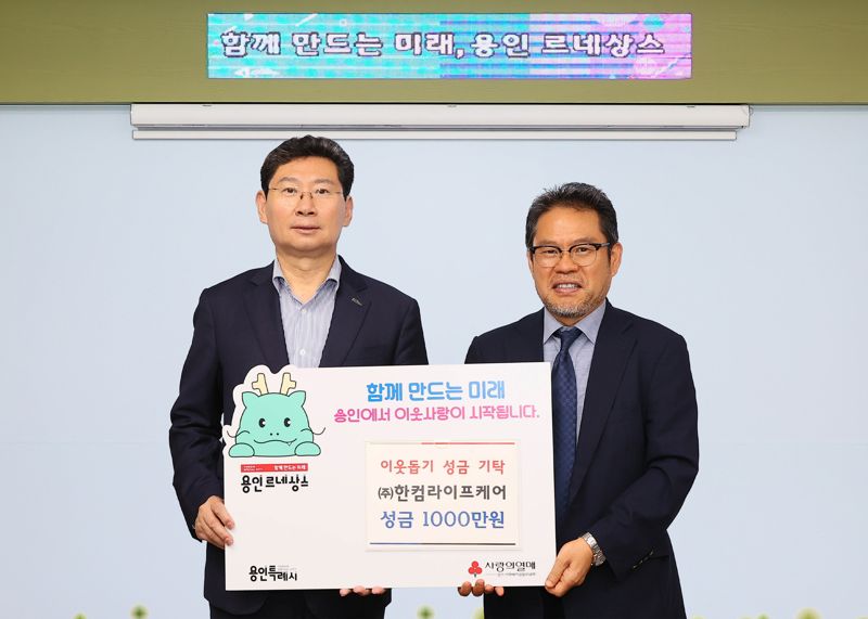 한컴라이프케어 오병진 대표(오른쪽)가 지난 10일 이상일 용인시장에게 이웃돕기 성금을 전달한 뒤 기념촬영을 하고 있다. 한컴라이프케어 제공