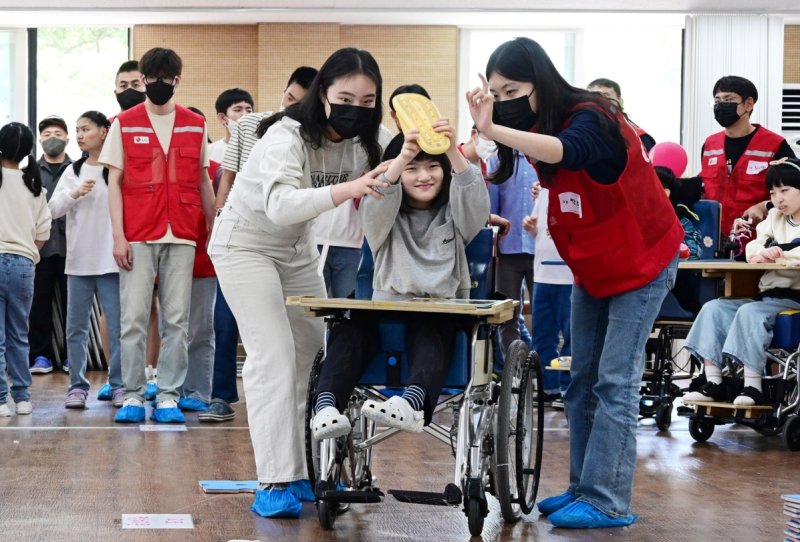 LG전자 임직원들이 지난 5월 서울시 강동구에 위치한 암사재활원에서 열린 '오늘은 어린이날' 행사에서 장애 아동 및 청소년들과 함께 운동회에 참여하고 있다.