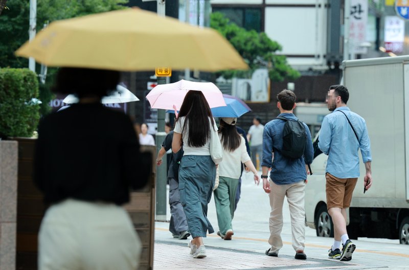 전국적으로 장맛비가 내리는 16일 오후 서울 중구 명동거리 인근에서 시민들이 우산을 쓰고 지나가고 있다. 뉴시스