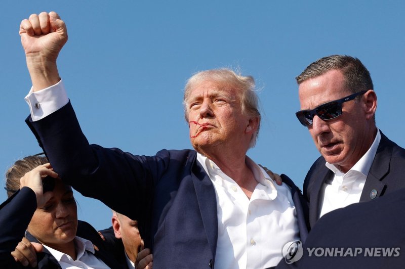 총격 뒤 지지자들에게 주먹을 든 트럼프 전 미국 대통령 BUTLER, PENNSYLVANIA - JULY 13: Republican presidential candidate former President Donald Trump pumps his fist as he is rushed offstage during a rally on July 13, 2024 in Butler, Pennsylvania. Anna Moneymaker/Getty Images/AFP (Photo by Anna Moneymaker / GETTY IMAGES NO