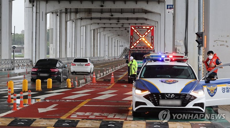 서울에서 새벽부터 이어진 강한 비가 소강상태를 보이는 가운데, 이번 비가 18일 낮에 그칠 전망이다. 비는 19일 낮에 다시 내리기 시작해 20일까지 이어질 것으로 보인다. 18일 오전 서울 잠수교 남단에서 경찰이 보행자 통행을 통제하고 있다. 연합뉴스