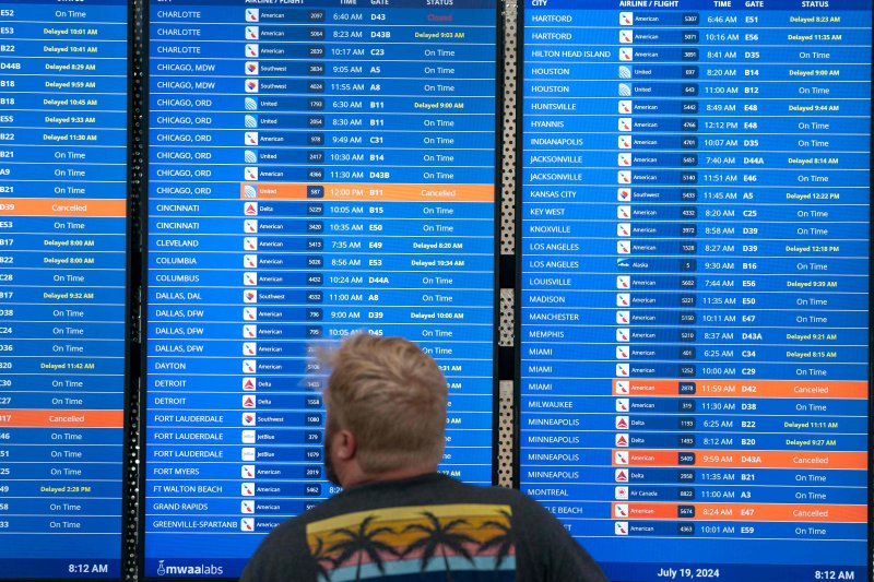 WASHINGTON, DC - JULY 19: A traveler checks flight information at Ronald Regan Washington National Airport on July 19, 2024 in Washington, DC. A global computer outage started from an update from the cybersecurity company CrowdStrike that impacted flights worldwide along with disrupting broadcasters