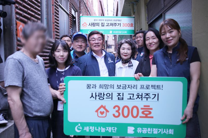 세정그룹 박순호 회장(앞줄 왼쪽 세번째)과 임직원 등이 '사랑의 집 고쳐주기' 300호 달성을 기념해 포즈을 취하고 있다. 세정그룹 제공