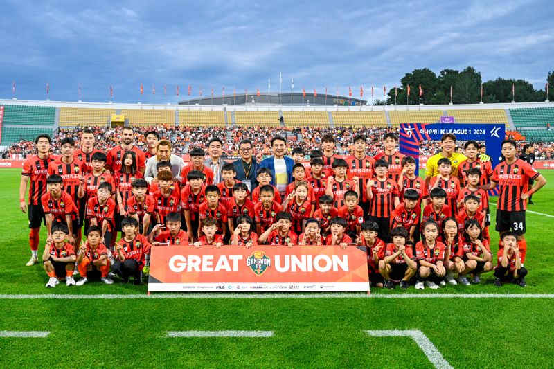 20일 강릉종합운동장에서 열린 '하이원 브렌드데이'에서 강원랜드 임직원 자녀들로 구성된 에스코트 키즈들과 주요 내빈, 강원FC 선수들이 기념촬영을 하고 있다. 강원FC 제공